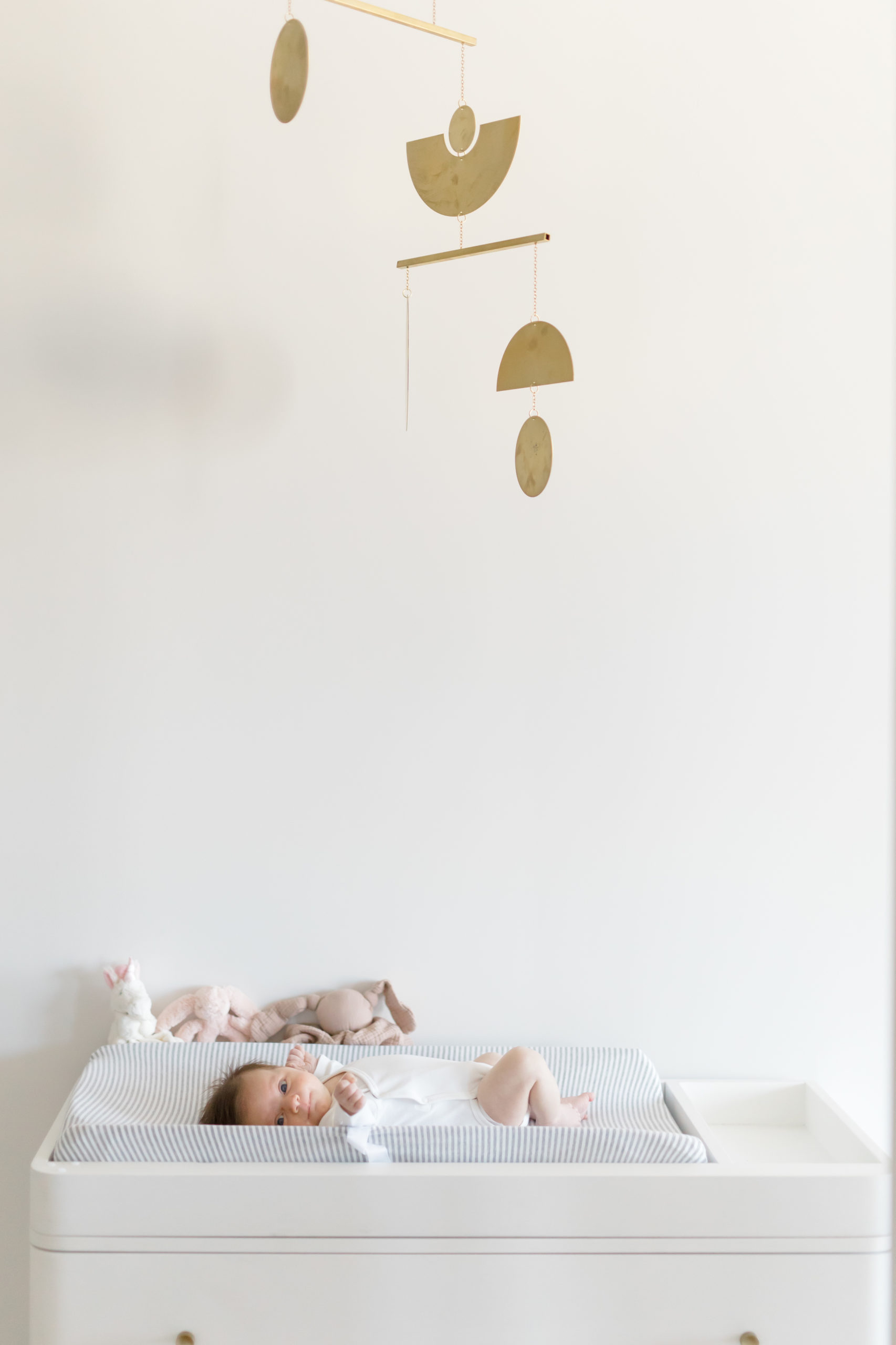 A baby on her changing table at an in home newborn photography session in NYC shot by Jacqueline Clair Photography
