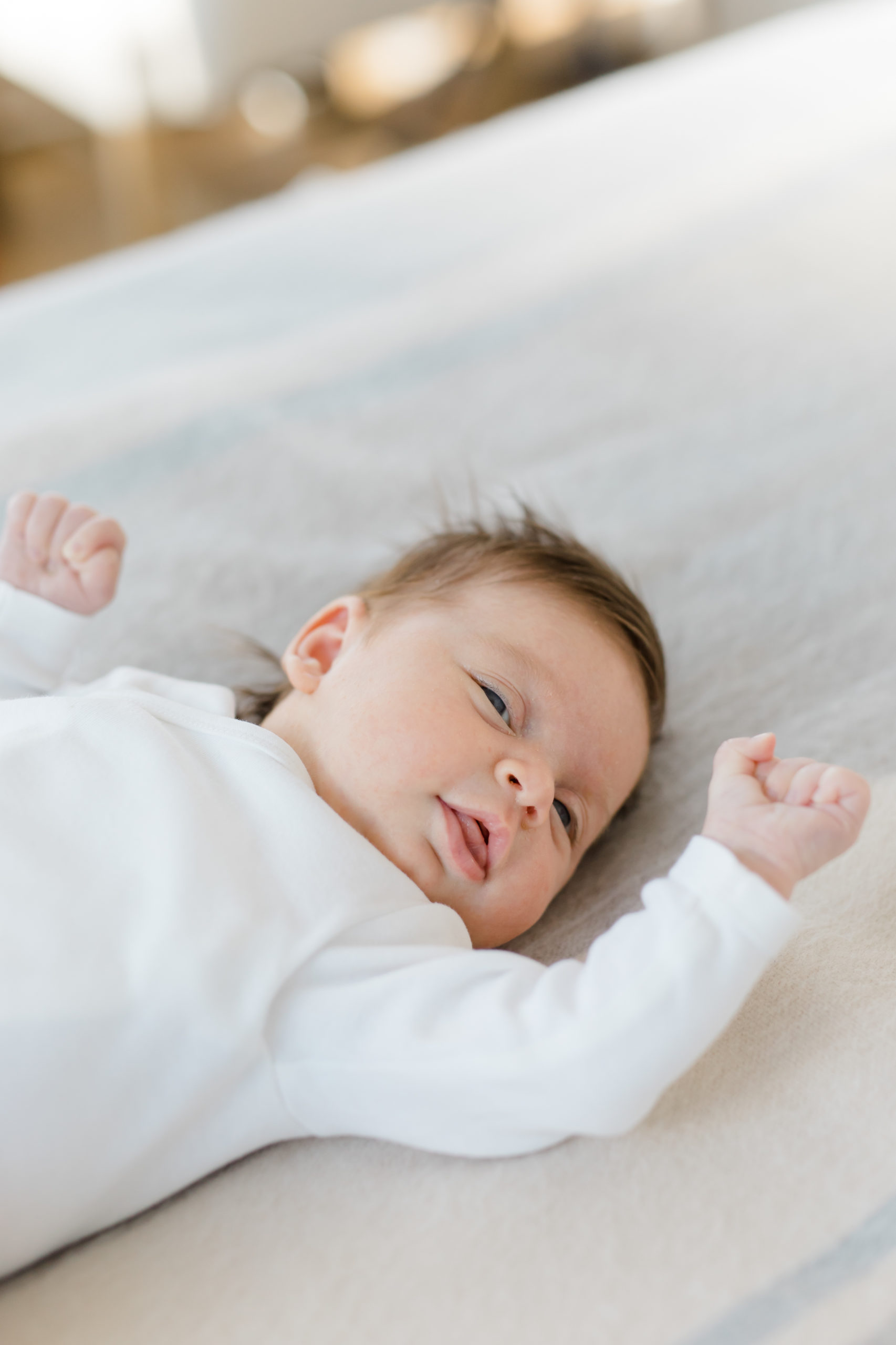 A close-up portrait of a baby on a bed at an in home newborn photography session in NYC photographed by Jacqueline Clair Photography. 