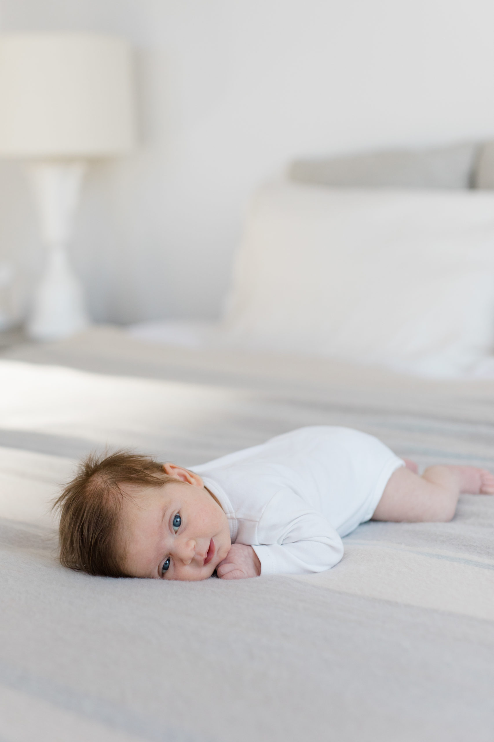 A baby girl does tummy time at an in home newborn photography session in NYC photographed by Jacqueline Clair Family Photography. 