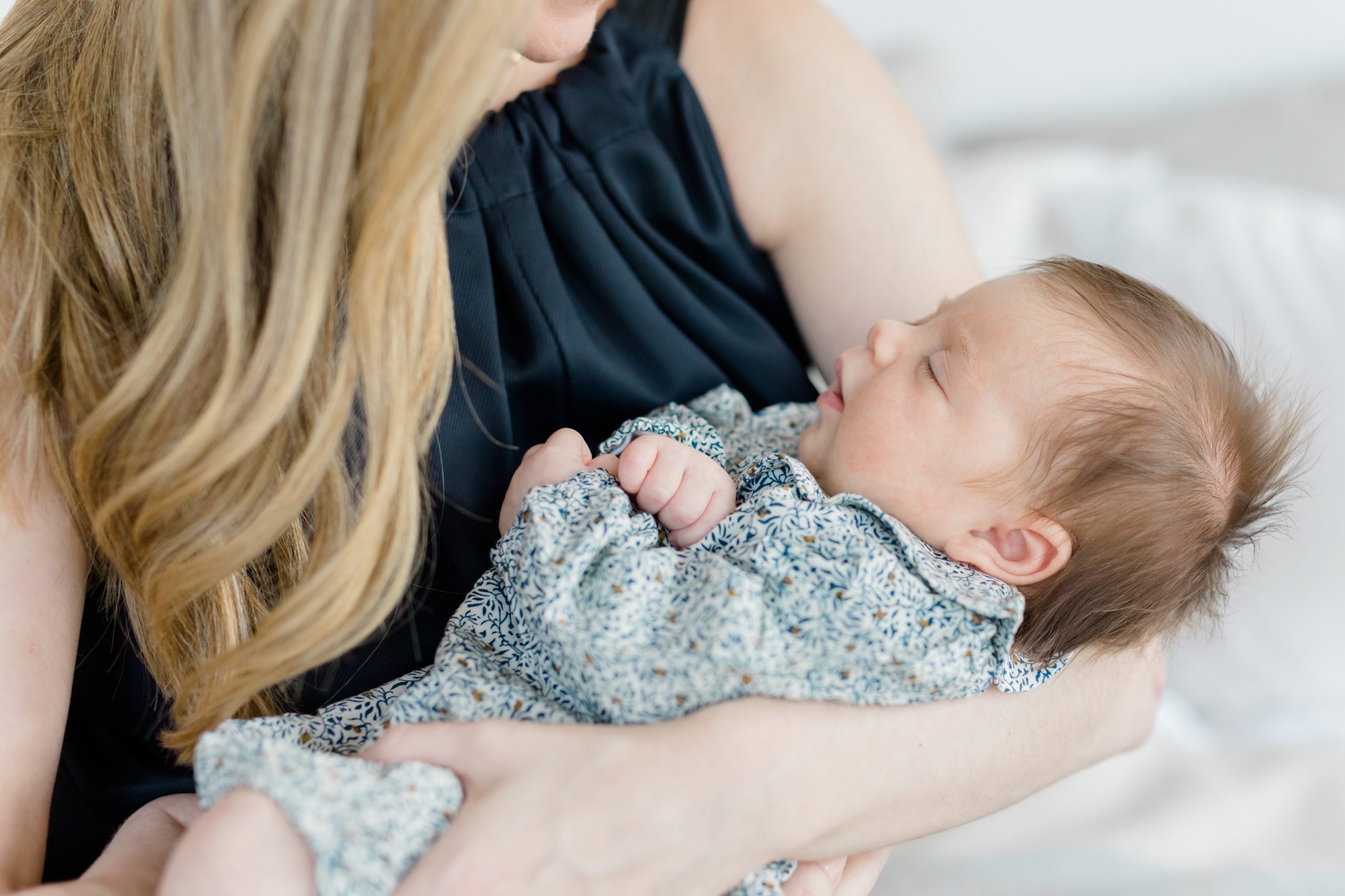 A close up of a baby in her mom's arms wearing a Maisonette outfit at an in home newborn photography session in New York City shot by Jacqueline Clair Photography. 