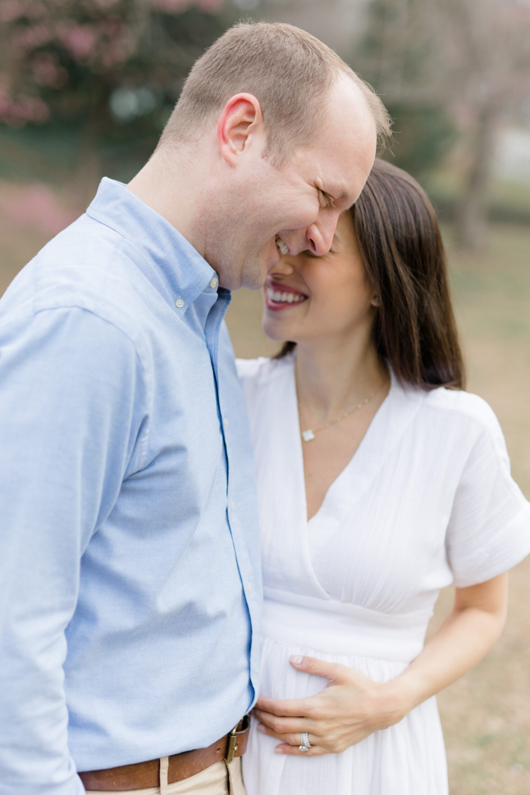 A pregnant couple laugh together at a New York City maternity photography session with Jacqueline Clair Photography