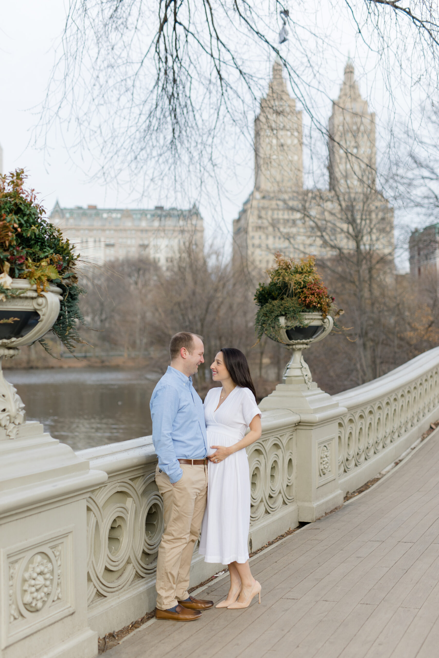 A couple laugh in Central Park during a New York City maternity photography session with Jacqueline Clair Photography