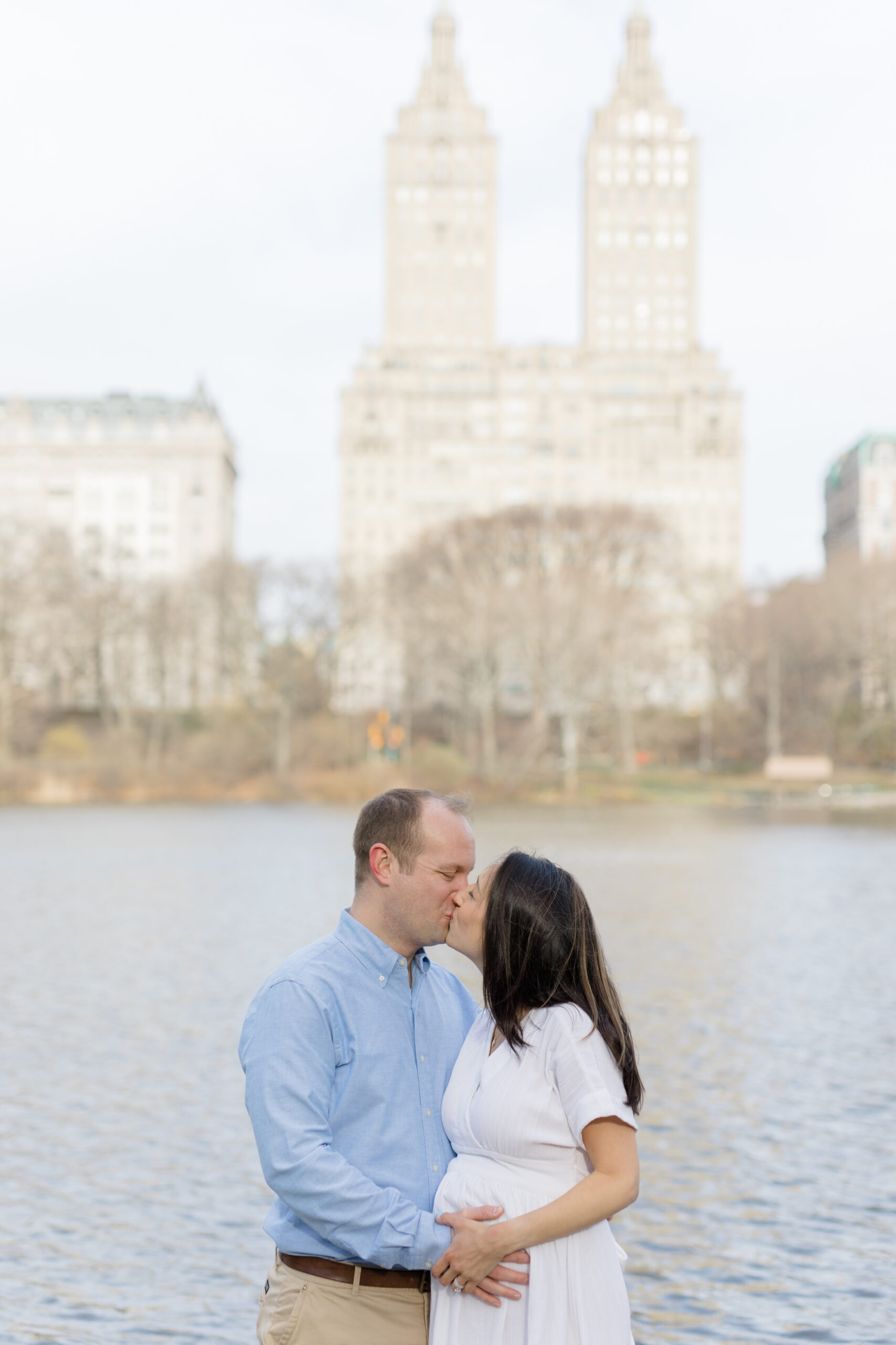 An expecting couple kiss in Central Park during a New York City maternity photography session with Jacqueline Clair Photography