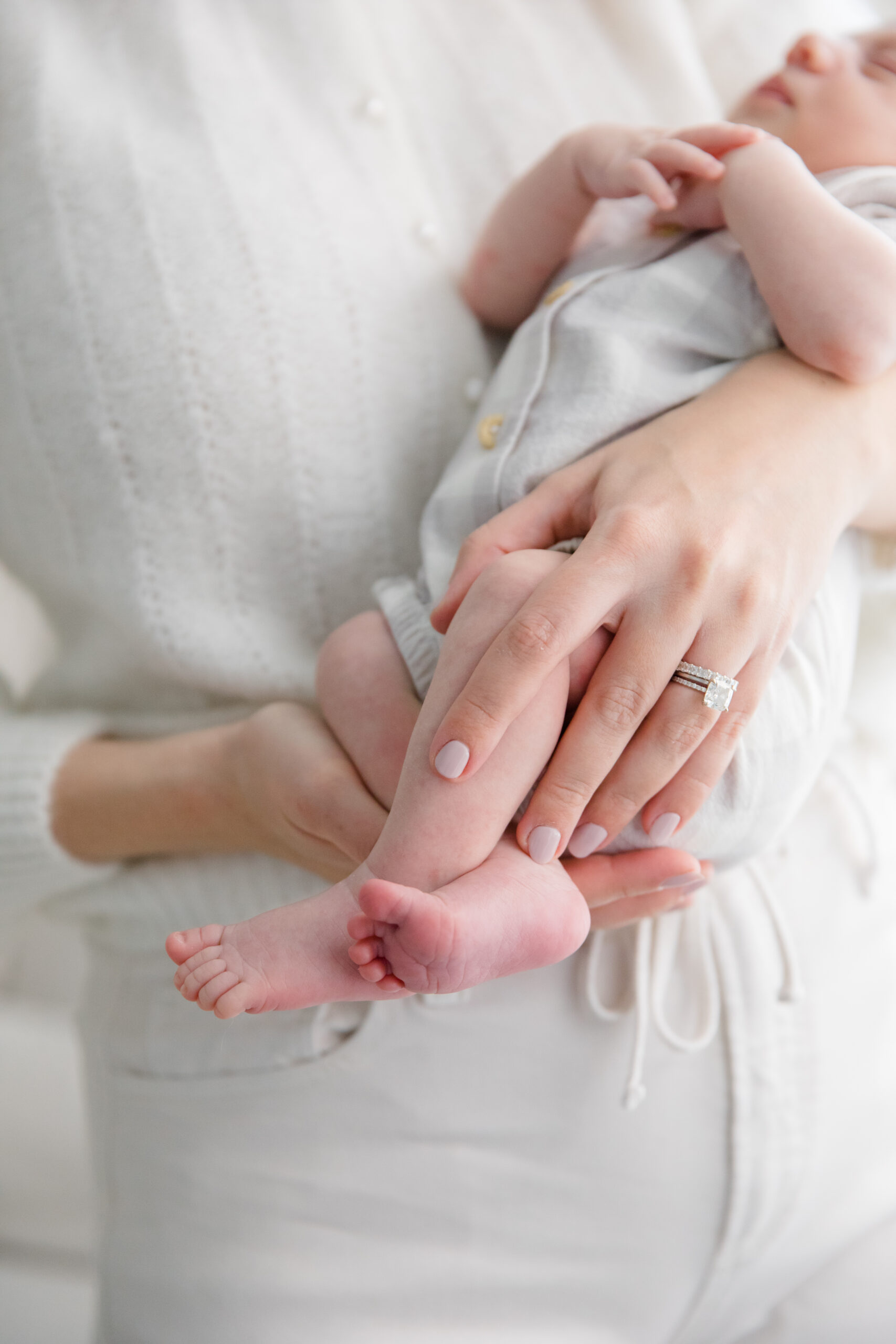A close up of a mom's hands holding her baby at a newborn session with New York City newborn photographer Jacqueline Clair