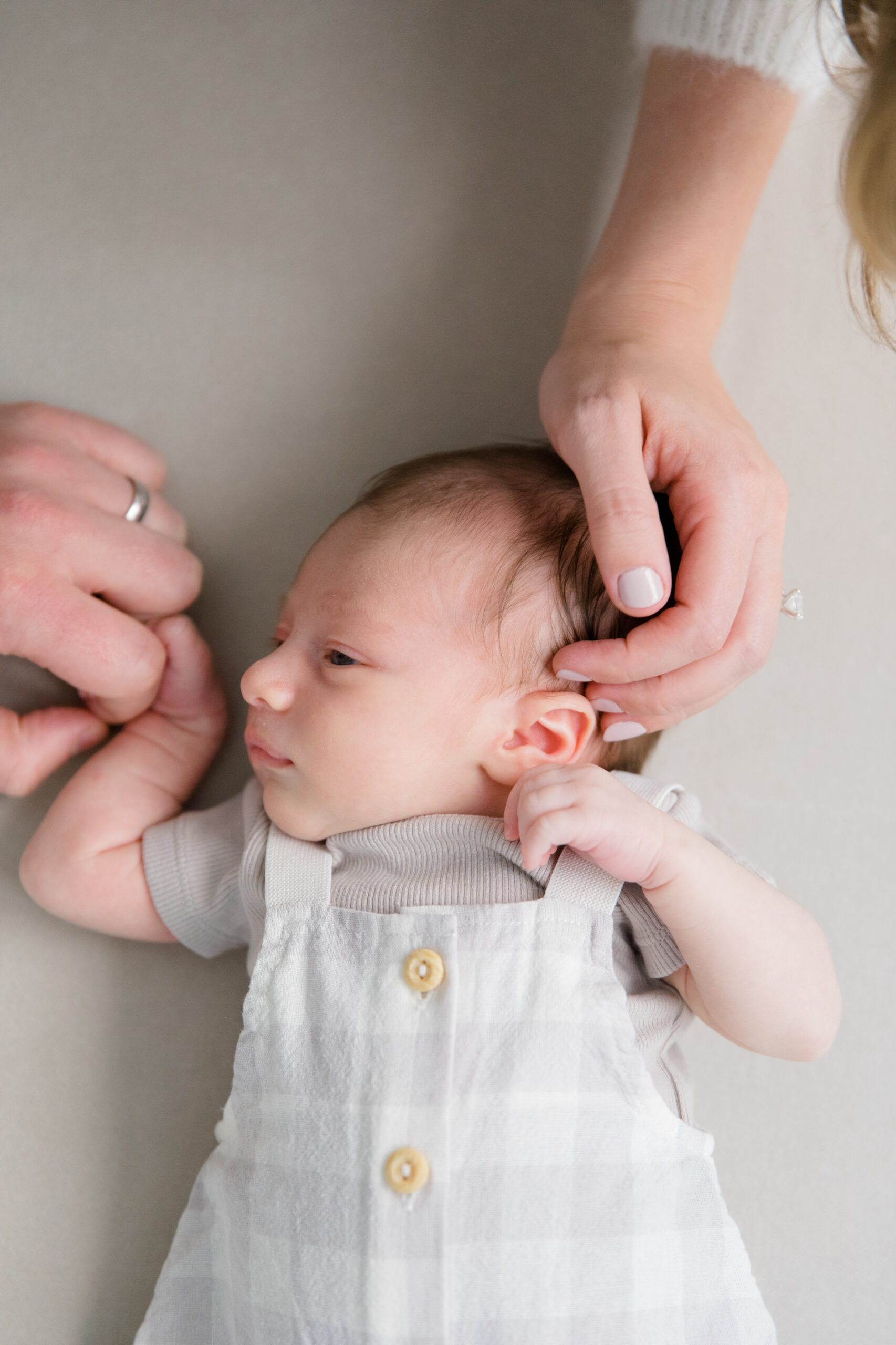 A mom and dad's hands on their baby  at a newborn session with New York City newborn photographer Jacqueline Clair
