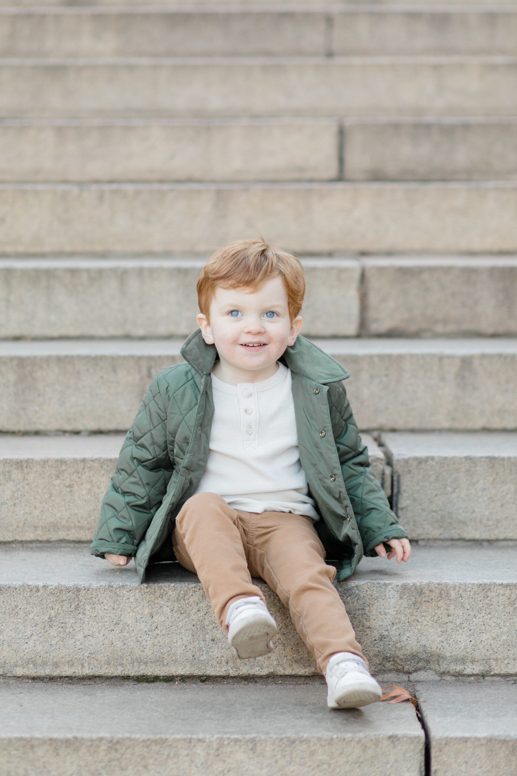 A little boy smiles in Central Park at a fall family session photographed by Jacqueline Clair Photography