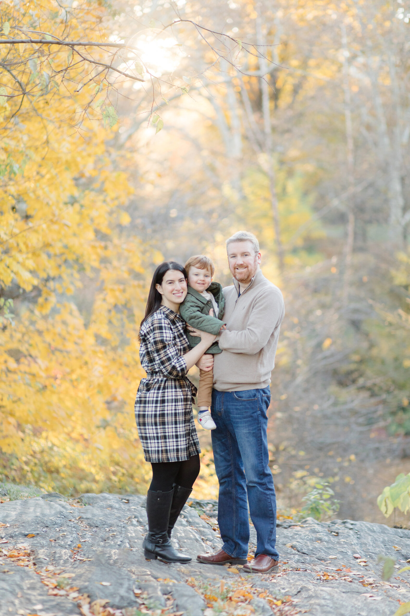 A mom, dad, and young son in Central Park at a fall family session photographed by Jacqueline Clair Photography