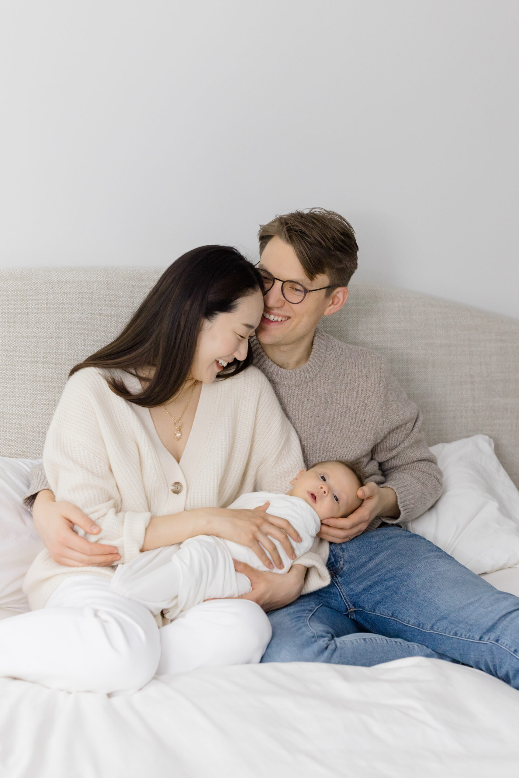 A couple and their baby wearing neutral shades at their lifestyle newborn session 