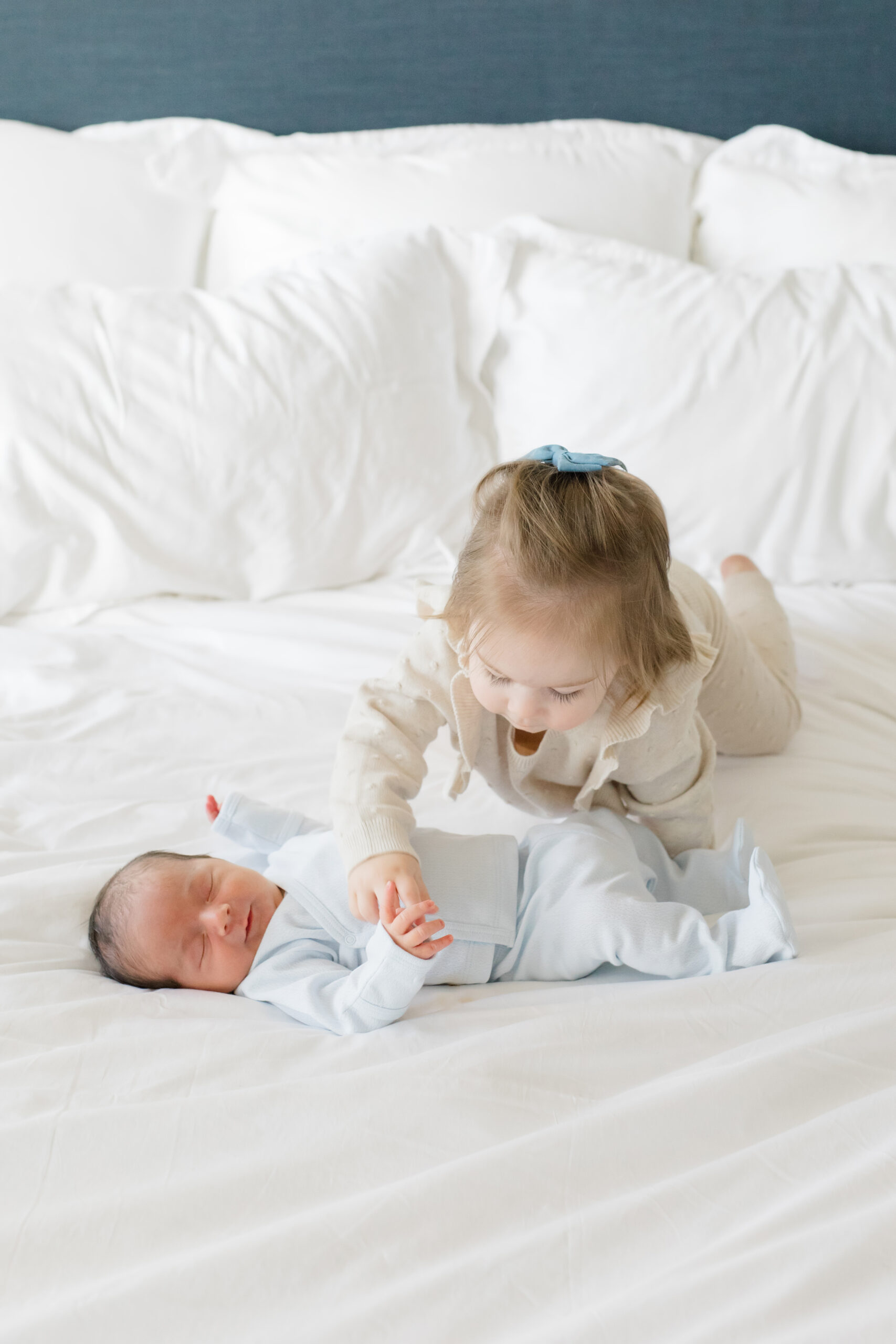 Two siblings wear neutral colors at a lifestyle newborn session 