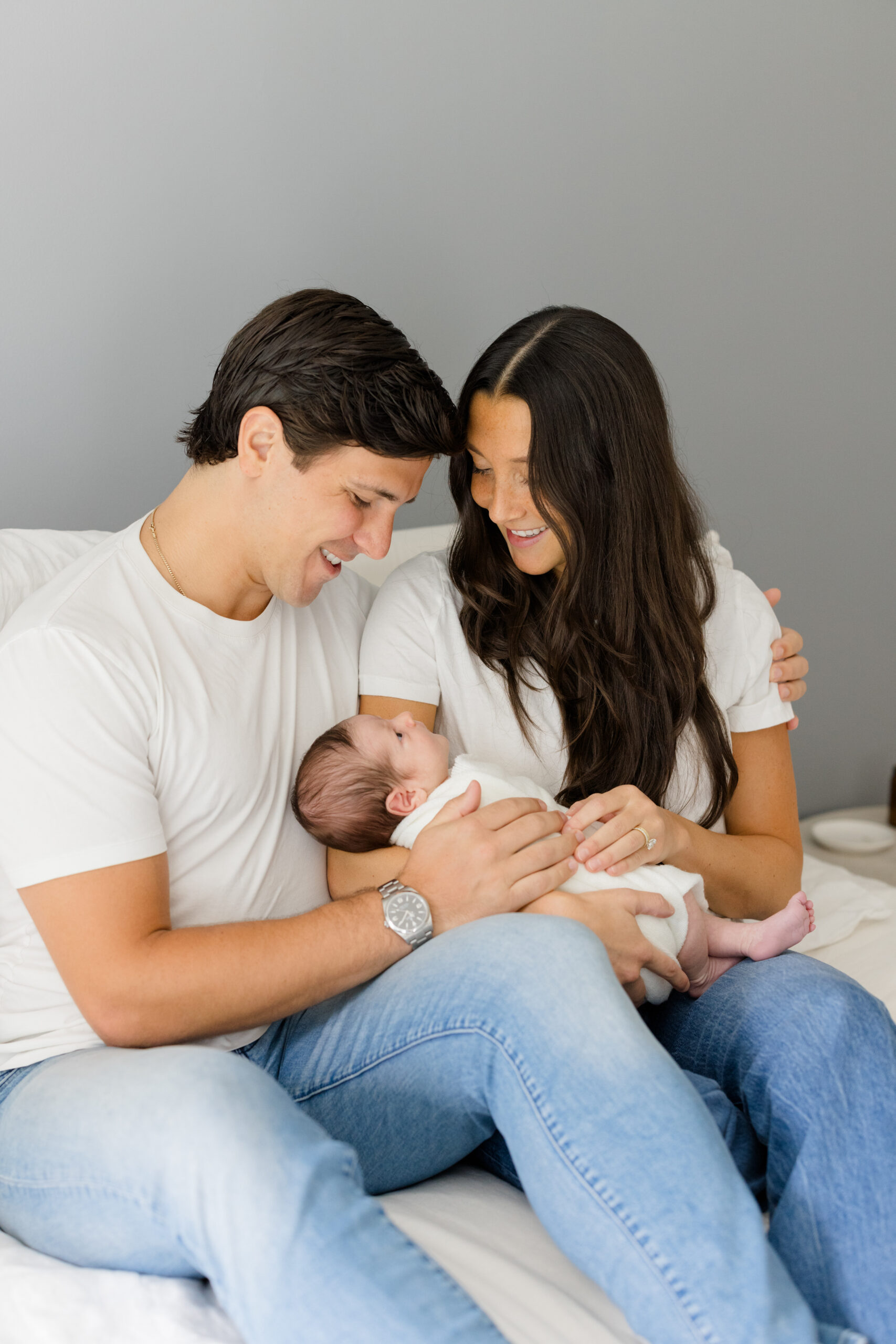 A couple in denim and white t shirts at their lifestyle newborn session 