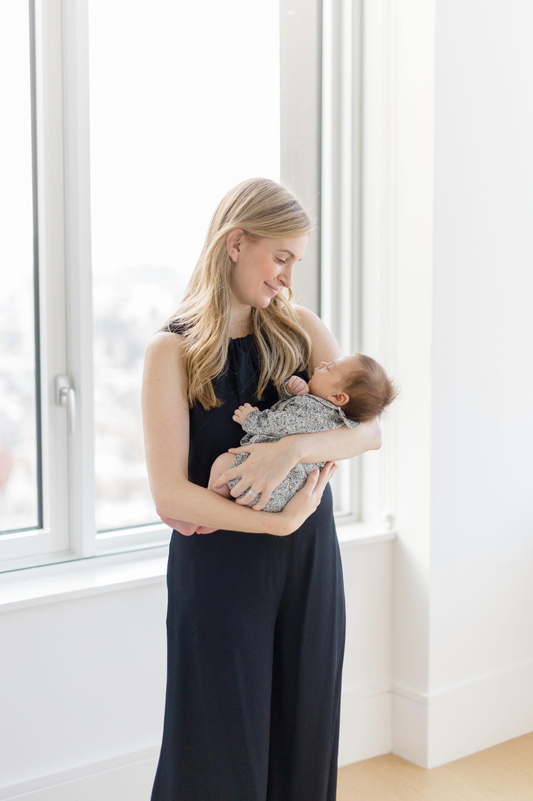 A woman in black at her lifestyle newborn session